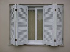 an open window with white shutters on the outside