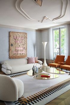 a living room filled with furniture and a painting hanging on the wall above an area rug