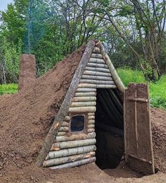 a pile of dirt with a house made out of bamboo sticks