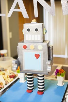 a toy robot is standing on a blue mat in front of some plates and food