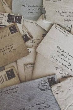 old letters and envelopes are piled on top of each other in an arrangement,