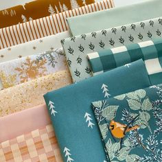 many different fabrics are stacked on top of each other, including one with a bird