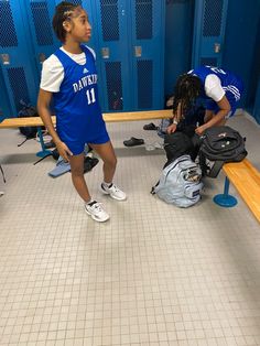 two young men standing next to each other in a locker room