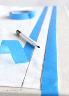 a table with blue tape and a pen on it