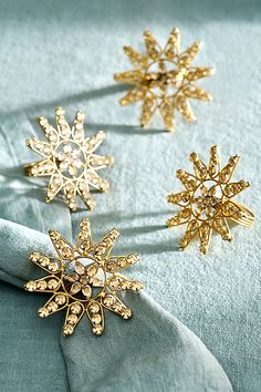 three gold snowflakes are sitting on a blue cloth