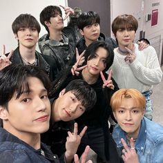 group of young men making peace signs with their hands