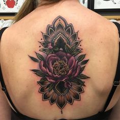 a woman's back with a flower tattoo on it