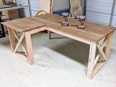 a table made out of wood sitting in a garage next to a pair of scissors