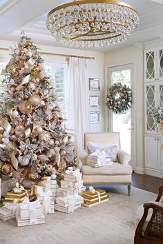 a decorated christmas tree in a living room with gold and silver ornaments on the top