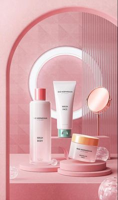 an assortment of skin care products displayed in front of a pink wall and circular mirror