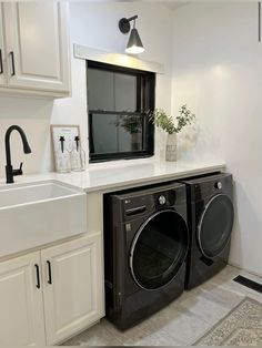 a washer and dryer in a white laundry room with black faucet