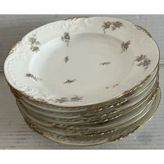 a stack of white and gold plates stacked on top of each other