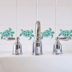 two chrome faucets with sea turtle decals on them