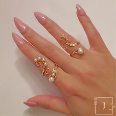 a woman's hand with two rings and pearls on it, one is gold