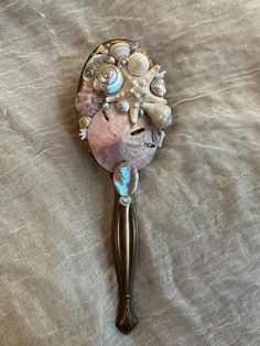 One of a kind upcycled vanity hair brush made with seashells, diamonds, pearls, coral, miscellaneous jewelry, starfish, abalone, sand dollar, and other oceanic materials ✨🫧  Approximately 3 inches wide by 1p inches long, handle with care it's delicate 🐚 Mermaid Hair Brush, Seashell Hairbrush, Seashell Jewelry Holder, Mermaid Trinkets, Upcycled Vanity, Mermaids Aesthetic, Brush Aesthetic, Mermaid Items, Seashell Diy