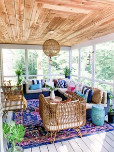 a living room filled with lots of furniture on top of a blue and white rug