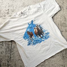 WAS $28 ★More 50% off items here: https://www.etsy.com/shop/MsTips?section_id=7004066&ref=shopsection_leftnav_10Vintage Vintage white cotton tshirt with screen printed horses on front. Single stitched.  Era✦ 1980s Material✦ 100% cotton Closure✦ pullover  Condition✦ few age spot, minor cracking of the graphic and cut off hem. (cleaned & comes from a smoke-free home) ✂Measurements: Please do not go by its original tag size. Always go by the measurements listed below!!taken flat and doubled. Fits l Vintage Cotton Printed T-shirt, Age Spot, Horse Shirt, Horse T Shirts, Vintage Horse, Dress Form, Mens Graphic Tee, Cut Off, White Vintage