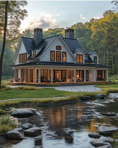 a large white house sitting on top of a lush green field next to a river