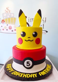 a birthday cake with a pokemon hat on top