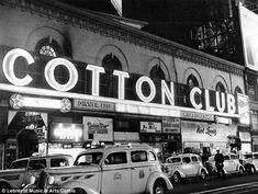 an old black and white photo of a cotton club with cars parked on the street