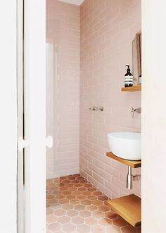 a bathroom with pink tiles and white fixtures