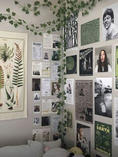 there are many pictures and plants on the wall in this room that is decorated with green leaves