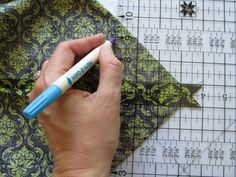 someone is using a sharpie to cut out the pattern for their fabric or quilt