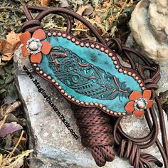 a blue and brown purse sitting on top of a rock