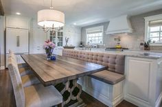 a kitchen with a table, chairs and a bench next to the stove top oven