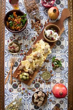 an assortment of food is laid out on a table with utensils and spoons