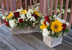 two wooden boxes filled with flowers on top of a table