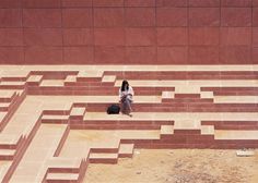 a woman sitting on the ground in front of a maze