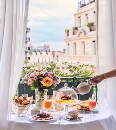 a table with food and drinks on it in front of a window