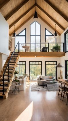 a living room filled with lots of furniture and tall ceiling beams on top of it