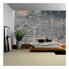 a bedroom with a brick wall behind the bed and potted plant next to it