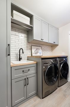 a washer and dryer sitting in a kitchen next to each other on top of cabinets