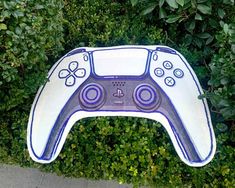 an overhead view of a video game controller in the grass with bushes and shrubs behind it