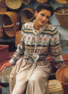 a woman sitting on top of a pile of baskets