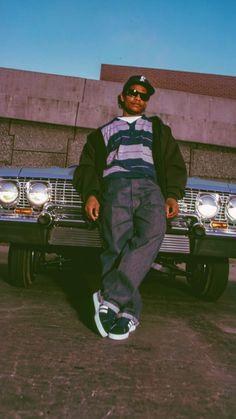 a man laying on the ground next to a car