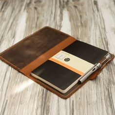 a notebook and pen sitting on top of a wooden table