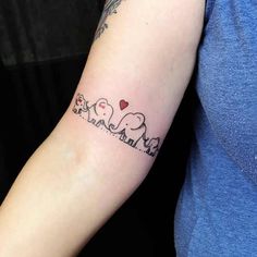 an elephant family tattoo on the arm with hearts and elephants in it's trunk