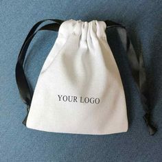 a white bag with the word your logo on it sitting on a blue carpeted floor