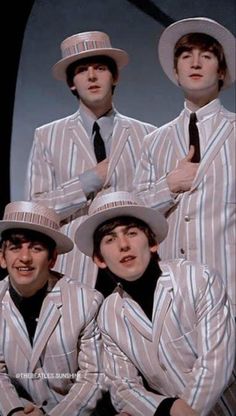 four men in suits and hats posing for a photo