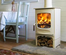 a stove that is sitting in the middle of a room next to a table and chair