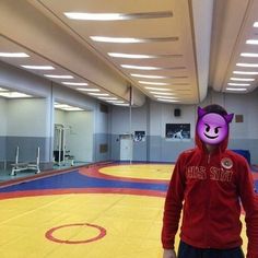 a person wearing a purple mask standing in a gym