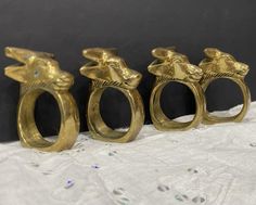 three gold rings with giraffes on them sitting on a white tablecloth