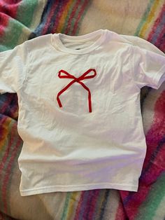 Simple bow ties with a ribbon sewed onto a cute baby tee! Handmade! Many colors available, if you don't see one you want send me a message and I'll work with you! Simple Diy Clothes, Baby Tee Embroidery, Gift Red Embroidered Top, Red Embroidered Tops Gift, Red Embroidered Top For Gift, Red Embroidered Tops As Gift, Cute Cotton T-shirt With Bow, Bows On Clothes, T Shirt Design Ideas Creative Diy