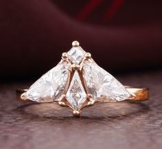 a three stone diamond ring sitting on top of a table