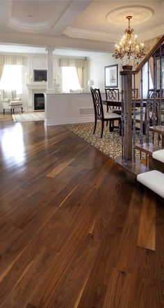 a living room filled with furniture and a chandelier on top of a hard wood floor