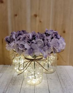 three mason jars with purple flowers in them